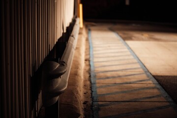 Closeup shot of a guardrail and corrugated steel siding on the sidewalk