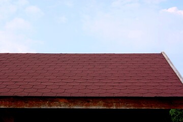 Shingle bituminous red tiles on a wooden gazebo building