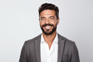 Portrait of a happy young businessman looking at camera over white background