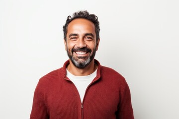 Obraz premium Portrait of a handsome Indian man smiling at the camera on white background