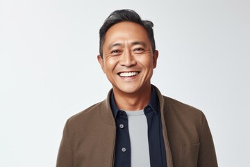 Portrait of a happy asian man smiling at camera over white background
