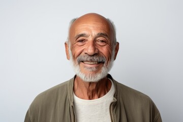 Obraz premium Portrait of a happy senior man smiling at the camera while standing against white background