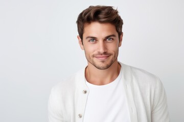 Fototapeta premium Portrait of handsome young man smiling and looking at camera over white background