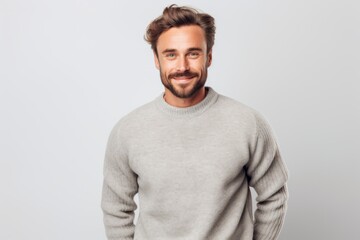 Portrait of a handsome young man smiling at camera over gray background