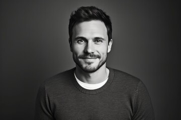 Fototapeta premium Black and white portrait of a Russian man in his 30s in a white background wearing a chic cardigan