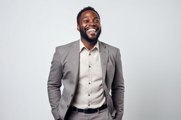 Portrait of a happy young african american businessman laughing over gray background