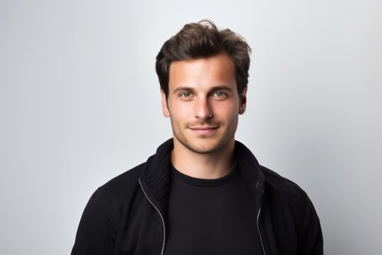 Portrait of handsome young man in black sweatshirt on grey background