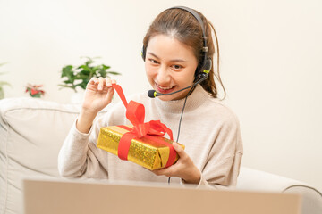 Celebrate on Christmas, new year season, asian happy pretty young woman, girl wearing headset, headphone and greeting on video call during social distance, showing present, gift box on merry xmas.