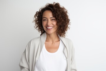 Portrait of beautiful young woman with curly hair smiling and looking at camera