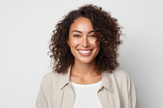 Portrait of a Brazilian woman in her 30s in a white background wearing a chic cardigan