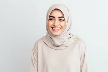 Medium shot portrait of a Saudi Arabian woman in her 30s in a white background wearing a cozy sweater