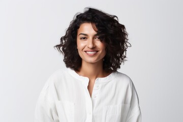 Portrait of a Saudi Arabian woman in her 30s in a white background wearing a chic cardigan