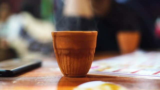 hot beverage like chai tea coffee with smoke coming out in a kullad clay pot which is traditionally used in india and is biodegradable and all natural