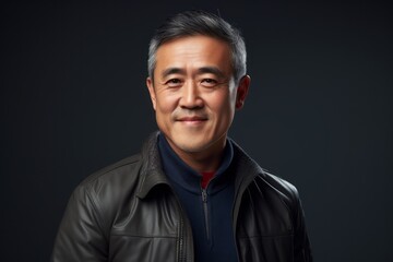 Portrait of an Asian man in a leather jacket on a dark background