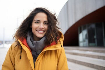 Portrait of a Brazilian woman in her 30s in a modern architectural background wearing a warm parka