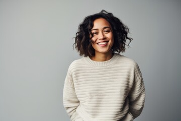 Obraz premium Portrait of a smiling young woman standing isolated on a gray background