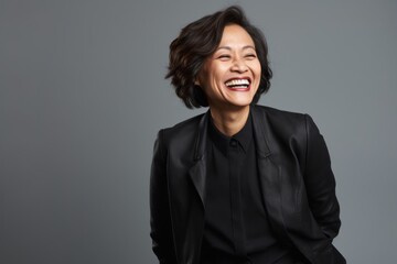 Portrait of a Indonesian woman in her 50s in a minimalist or empty room background wearing a classic blazer