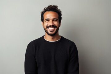 Obraz premium Portrait of a happy young man smiling at camera against grey background