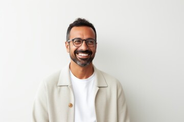 Portrait of a happy indian man in eyeglasses against white background