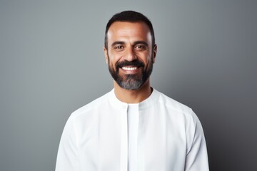 Obraz premium Portrait of a smiling middle-aged man in a white shirt on a gray background