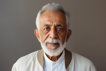 Portrait of an old man with grey hair in a white shirt