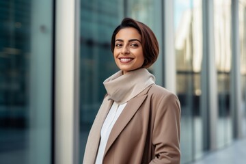 Portrait of a Saudi Arabian woman in her 30s in a modern architectural background wearing a chic cardigan