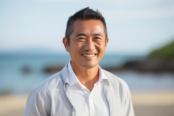 Portrait of happy mature man smiling at camera on the beach.