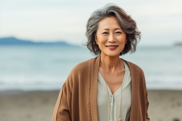 Portrait of a smiling senior asian woman standing on the beach