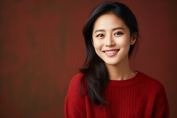 Portrait of a Chinese woman in her 30s in an abstract background wearing a cozy sweater