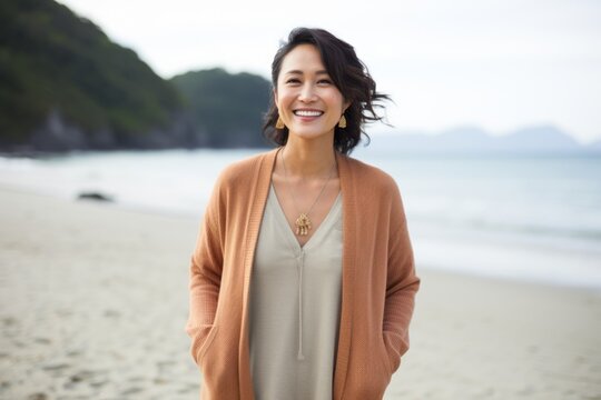 Portrait of smiling asian woman standing on the beach at seaside