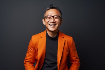 Fototapeta premium Portrait of a Chinese man in his 40s in an abstract background wearing a chic cardigan