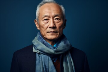 Medium shot portrait of a Chinese man in his 60s in an abstract background wearing a foulard