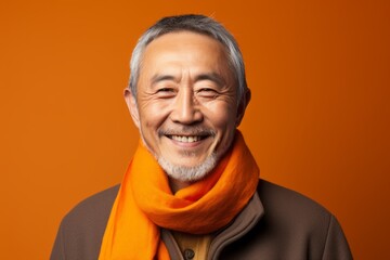 Medium shot portrait of a Chinese man in his 60s in an abstract background wearing a foulard
