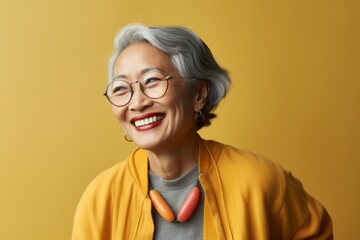 Portrait of a Chinese woman in her 70s in an abstract background wearing a chic cardigan