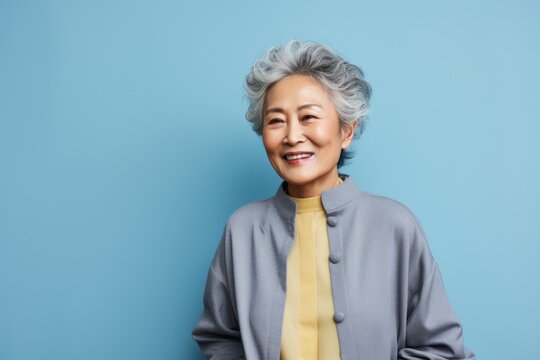 Portrait of a Chinese woman in her 70s in an abstract background wearing a chic cardigan