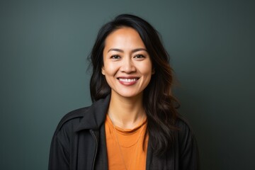 Fototapeta premium Portrait of a Indonesian woman in her 30s in an abstract background wearing a chic cardigan