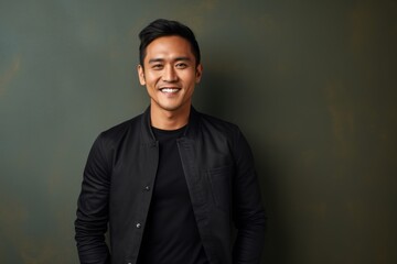 Obraz premium Portrait of a Indonesian man in his 30s in an abstract background wearing a chic cardigan