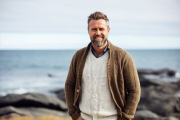 Portrait of a happy mature man standing on the seashore