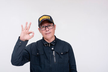 An asian male security guard giving the ok symbol, saying all will be alright. Isolated on a white...