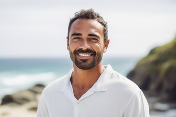 Portrait of smiling man standing on beach at the day time with ocean in background