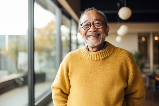 Portrait of a Indonesian man in his 80s in an abstract background wearing a cozy sweater