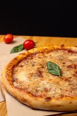 Close-up of hot baked margherita pizza garnished with basil leaf. Italian Cuisine. Menu for a pizzeria