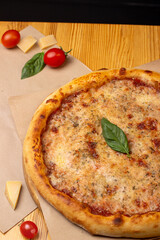 Close-up of hot baked margherita pizza garnished with basil leaf. Italian Cuisine. Menu for a pizzeria