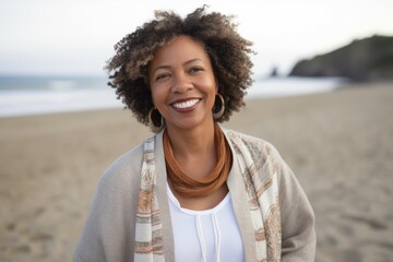 Front view of a smiling young woman with curly hair at the beach