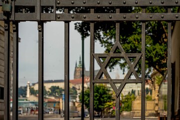 Closeup of an iron gate with a Star of David symbol on it in Prague, Czechia