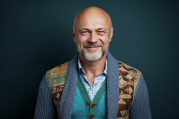 Fototapeta premium Portrait of a Russian man in his 50s in an abstract background wearing a chic cardigan