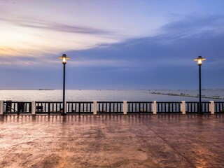 Naklejka premium the streetlight and benches near the water and a pier
