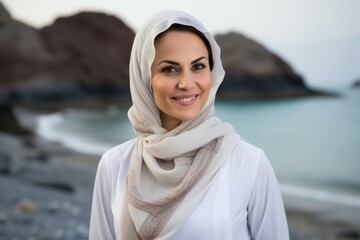 Portrait of beautiful young muslim woman wearing scarf on the beach