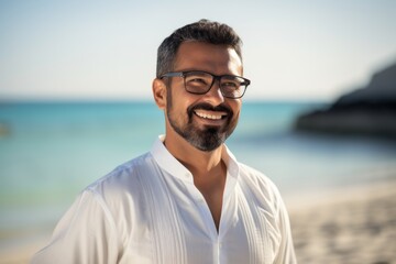 Portrait of smiling man with eyeglasses standing on the beach
