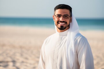 Portrait of a smiling arabic man with glasses on the beach